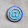 Dekorativt strygemærke til tøj Snabel a @ i  flotte grå og blå nuancer Ø 4,5 cm